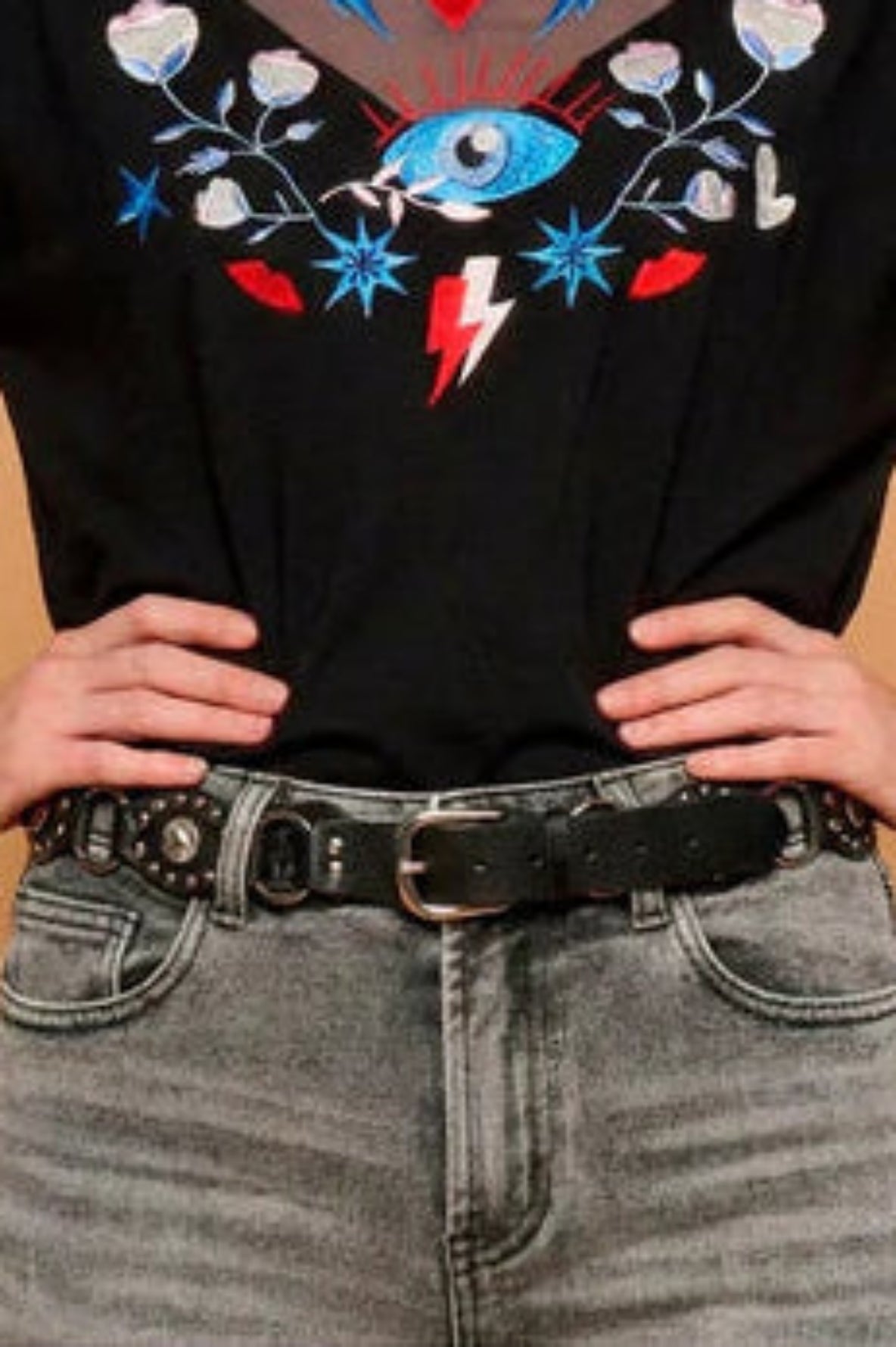 Hebilla metálica robusta en cinturón negro con tachuelas