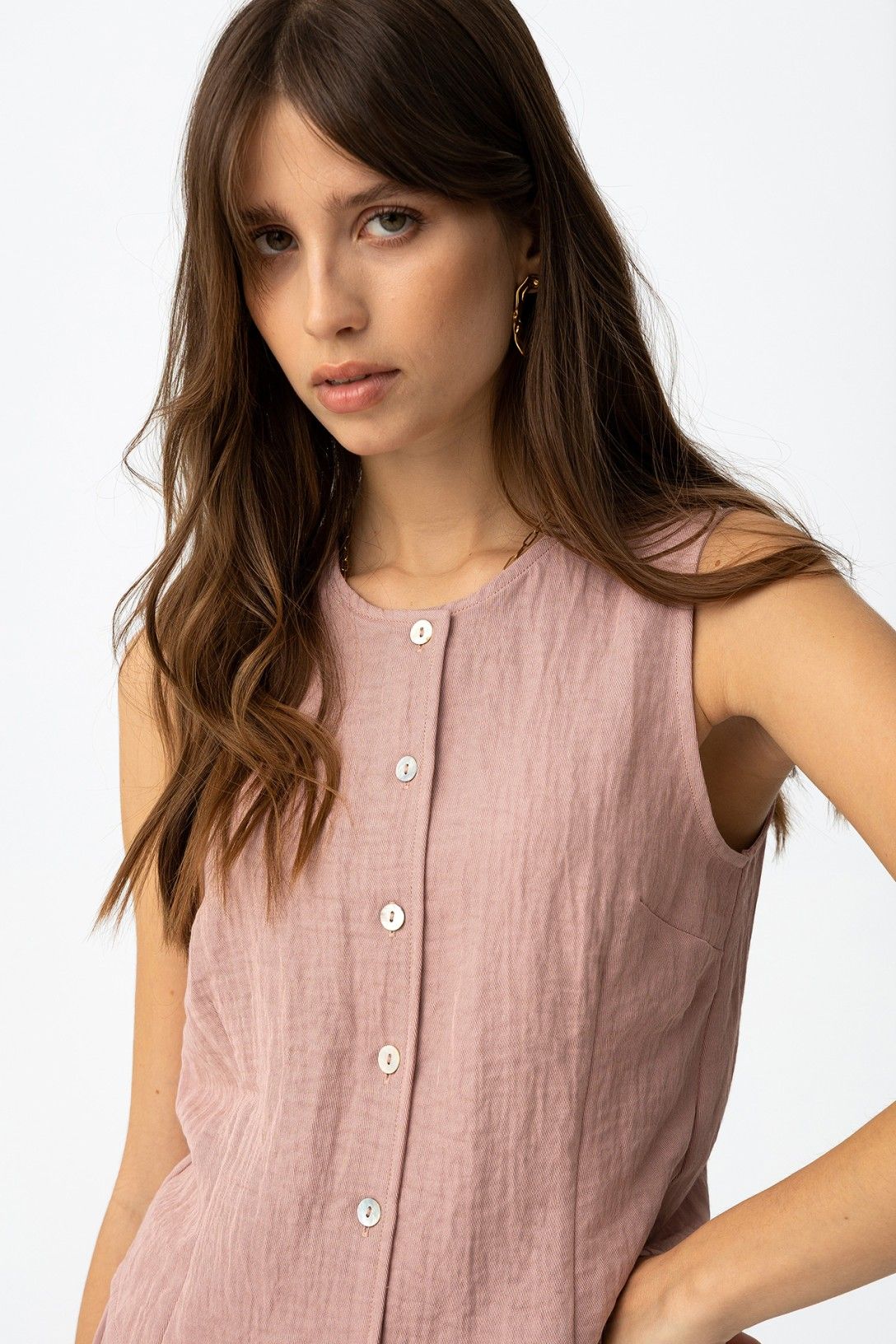 Detalle del escote en pico y botones de la blusa tipo chaleco.