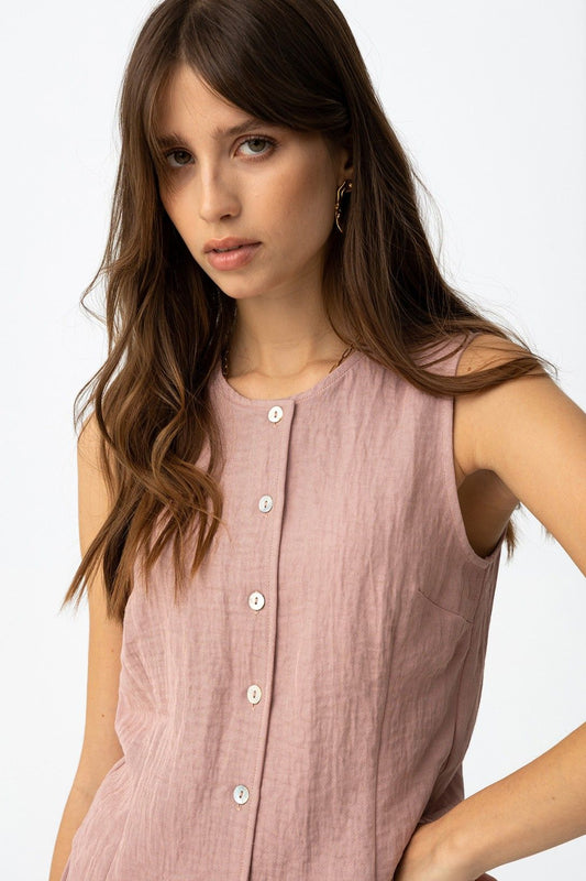 Detalle del escote en pico y botones de la blusa tipo chaleco.
