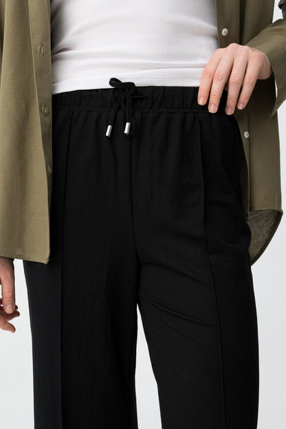 Detalle de la cintura elástica con cordón ajustable en pantalón