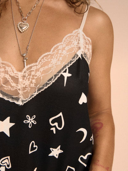 Detalle de los tirantes finos regulables de la camiseta lencera negra.