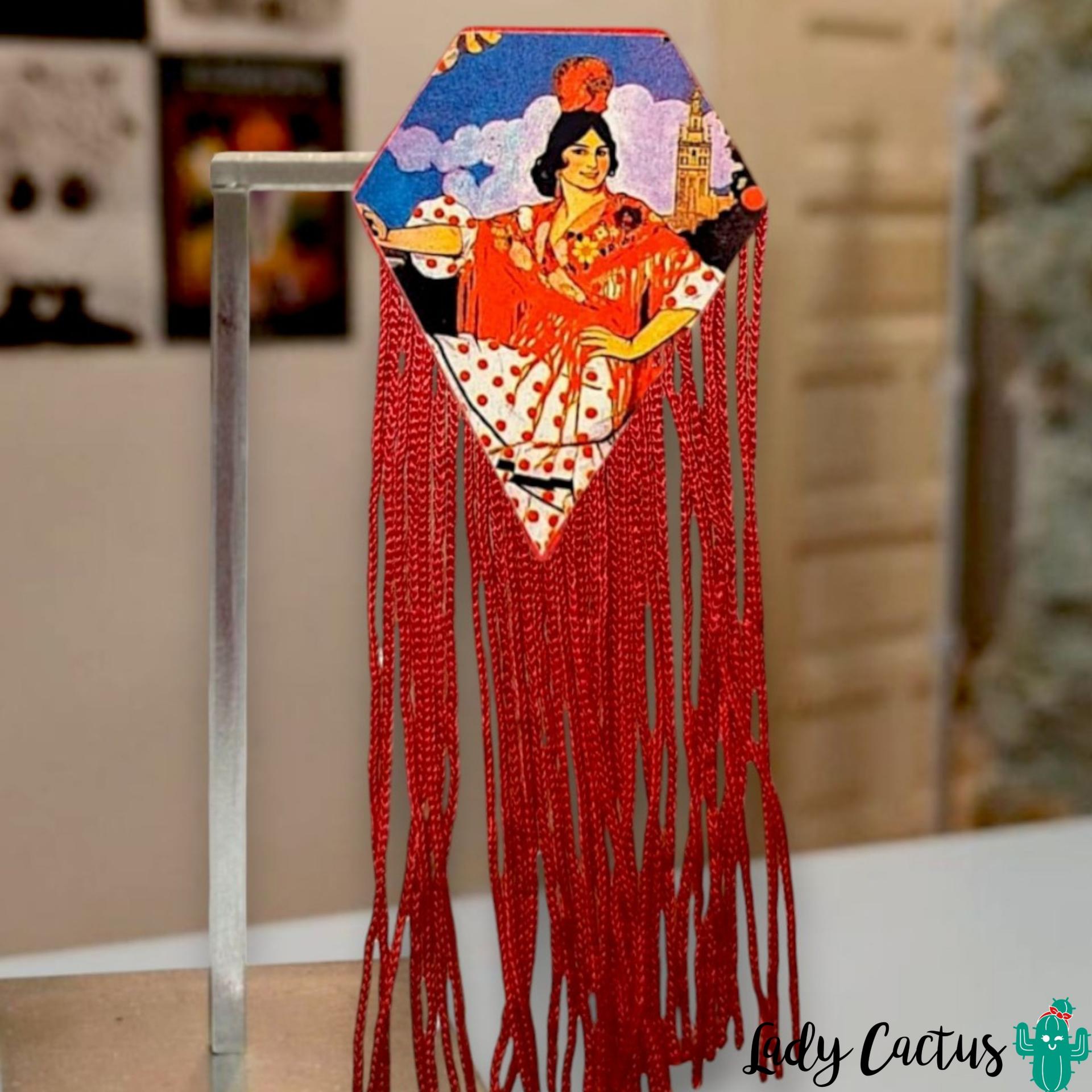 Detalle de los flecos rojos en cascada del broche diamante de flamenca