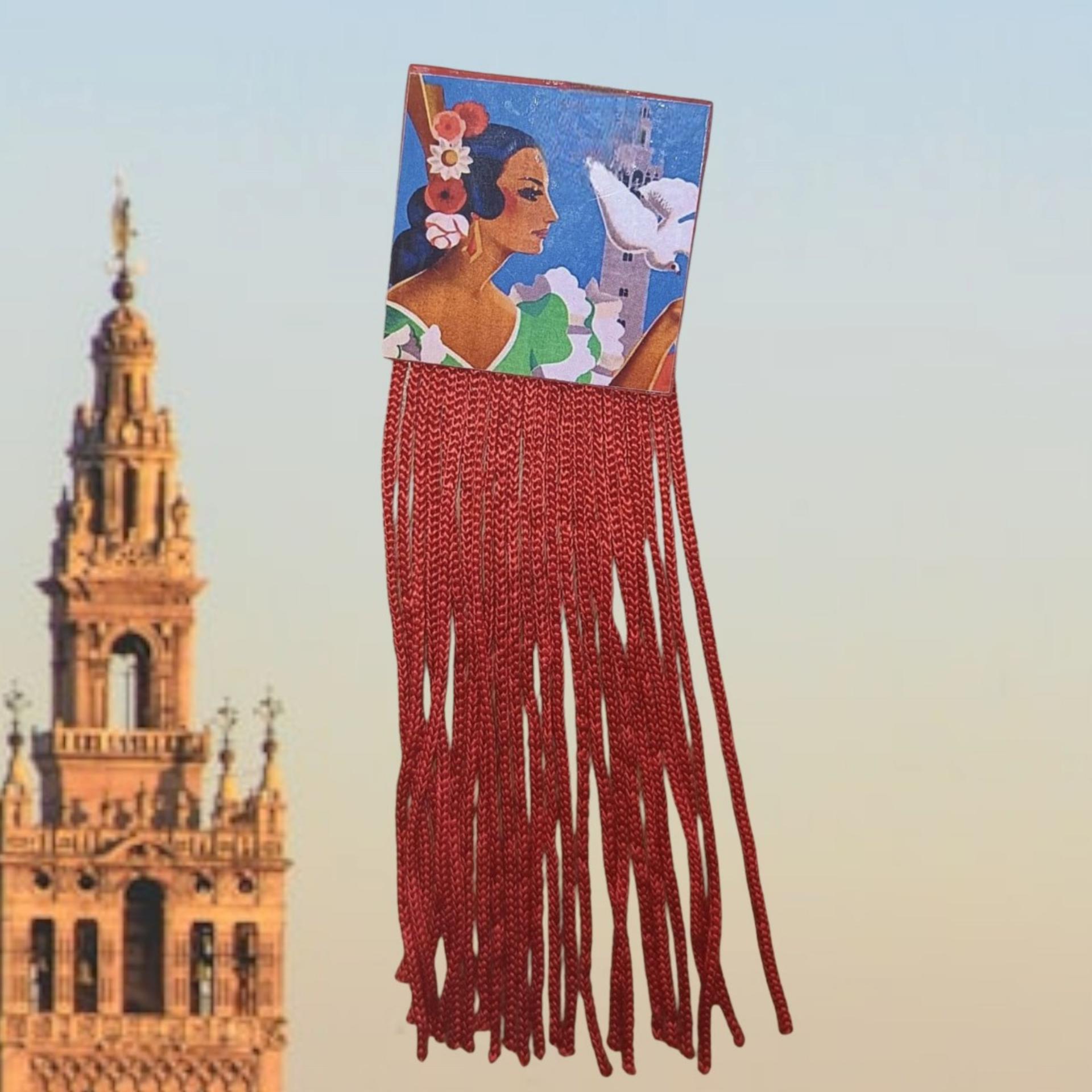 Detalle de los flecos de hilo rojos en el broche de madera cuadrado