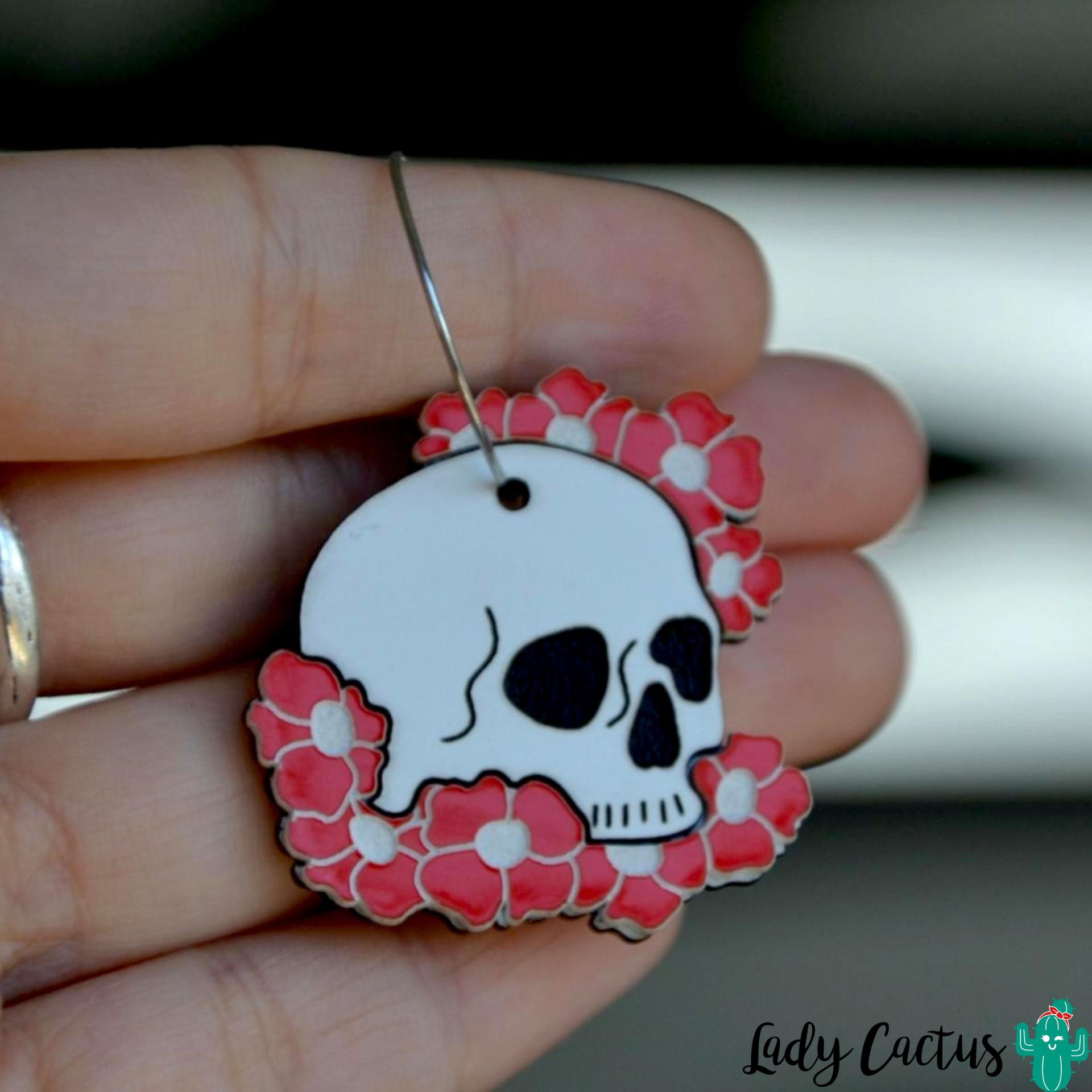 Detalle de los pendientes de calaveras y flores rojas hechos a mano