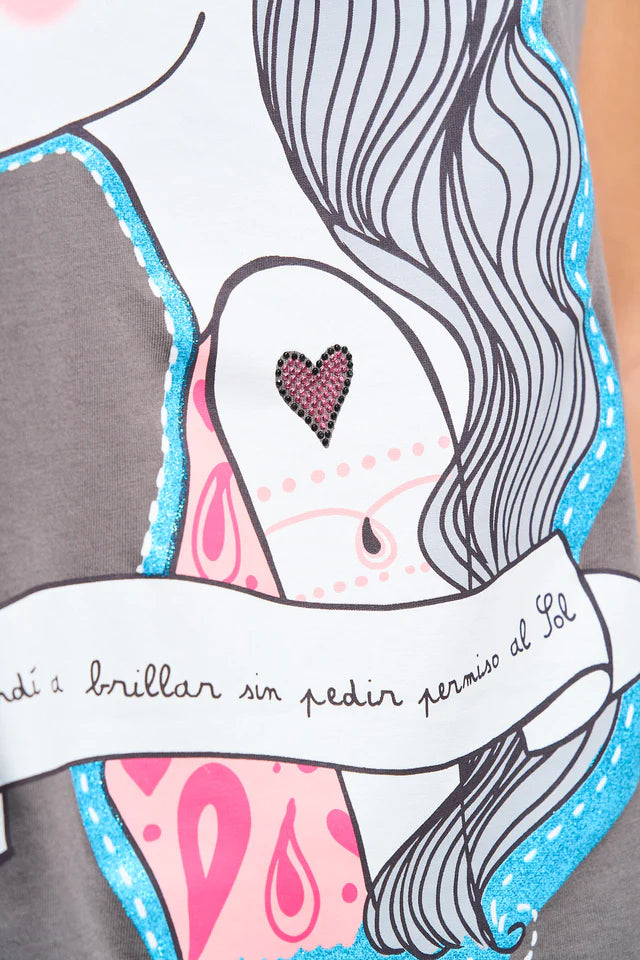 Detalle de la frase "aprendía a brilar sin pedir permiso al sol" en la camiseta de Anabel Lee.