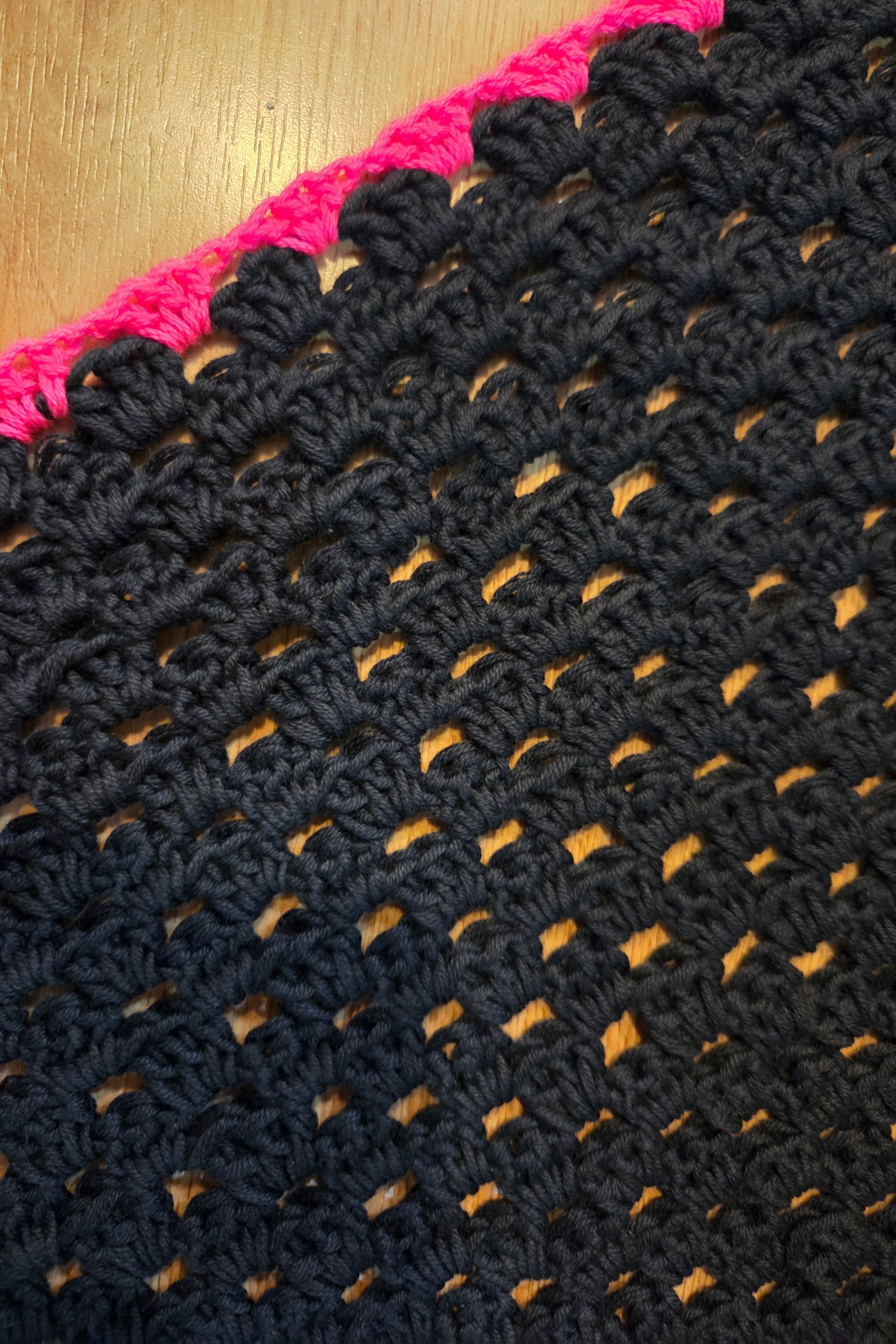 Detalle de puntilla rosa flúor en chal negro
