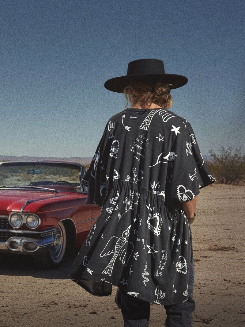 Kimono de algodón negro deslavado con estampado de poemas e ilustraciones blancas.