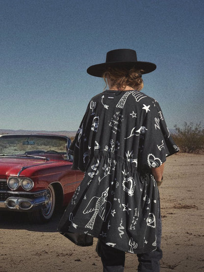 Kimono de algodón negro deslavado con estampado de poemas e ilustraciones blancas.