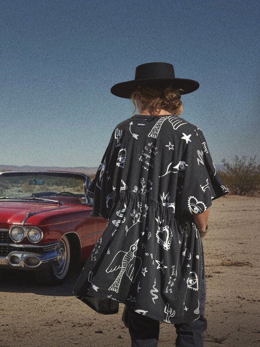 Kimono de algodón negro deslavado con estampado de poemas e ilustraciones blancas.