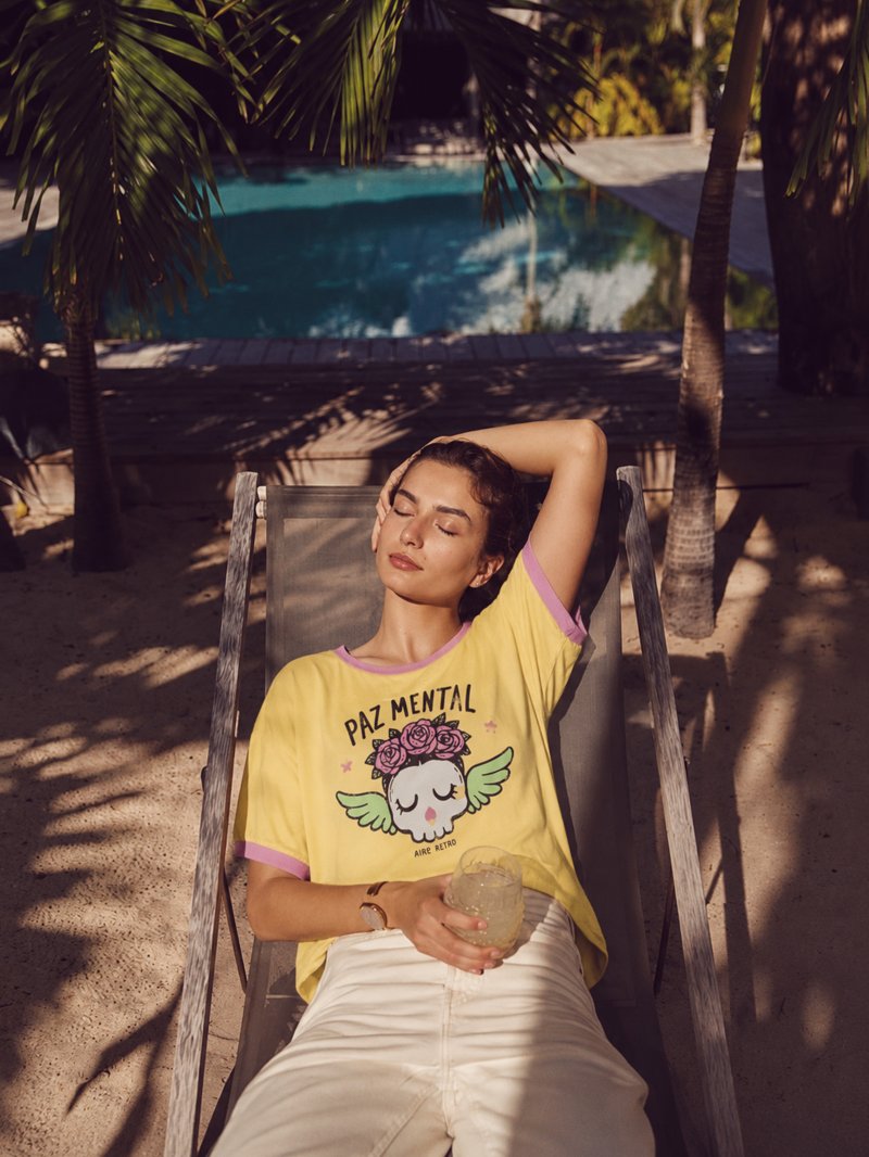 Modelo luciendo la camiseta Paz Mental con un look alegre.