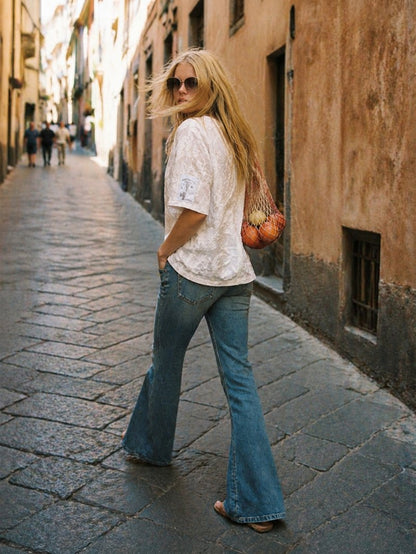 Look artesanal con camisa blanca bordada y botones joya