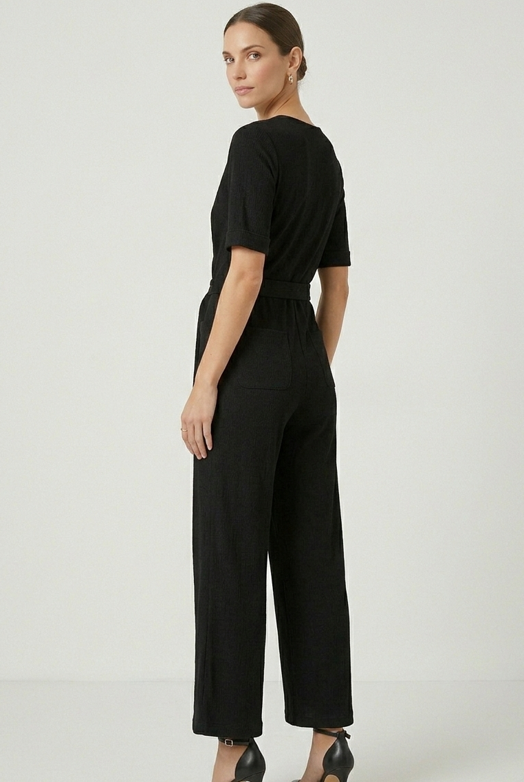 Prenda de una pieza negra con caída fluida y elegante